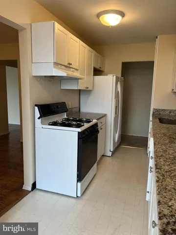 a kitchen with stainless steel appliances granite countertop a refrigerator a stove and a sink