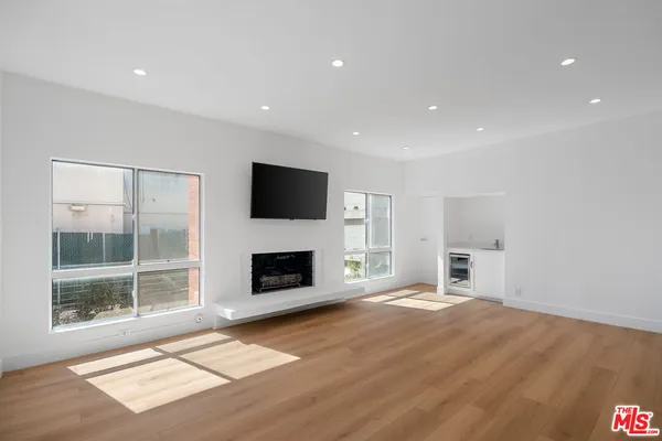 a view of livingroom with furniture wooden floor fire place and windows