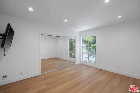 an empty room with wooden floor and sliding door