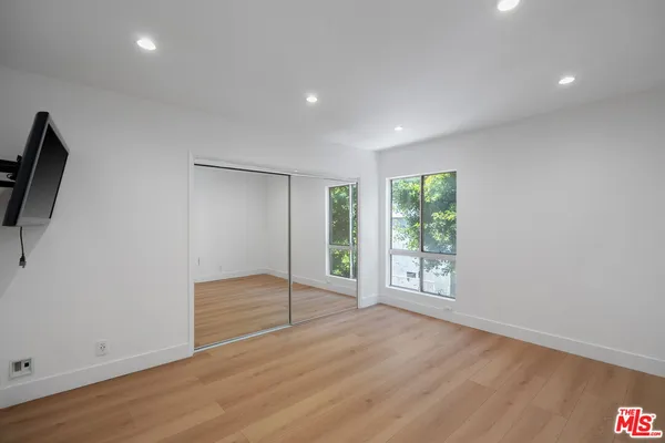 an empty room with wooden floor and sliding door