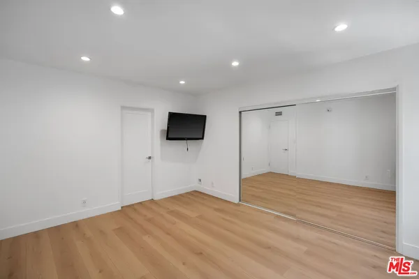 a view of empty room with wooden floor