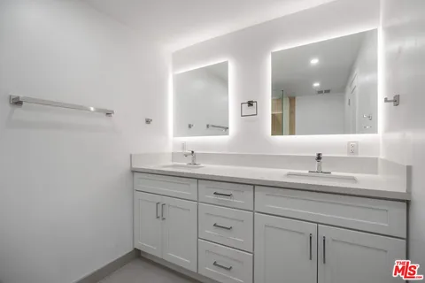a bathroom with a granite countertop sink double and mirror