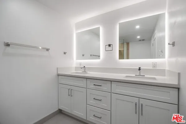 a bathroom with a granite countertop sink double and mirror