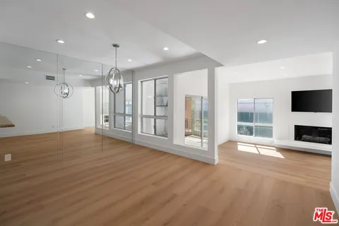 a view of an empty room with a fireplace and a window