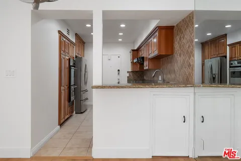a kitchen with stainless steel appliances granite countertop a refrigerator and a sink