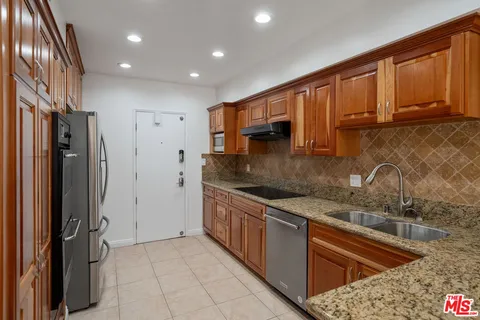 a kitchen with stainless steel appliances granite countertop a refrigerator sink and cabinets