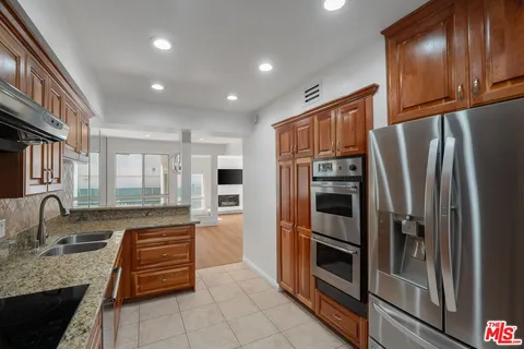 a kitchen with stainless steel appliances granite countertop a refrigerator and a sink