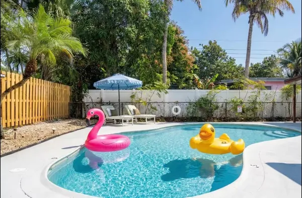 a view of a swimming pool with a table and chairs under an umbrella