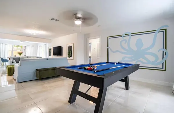 a kitchen with stainless steel appliances kitchen island granite countertop a table chairs sink and microwave