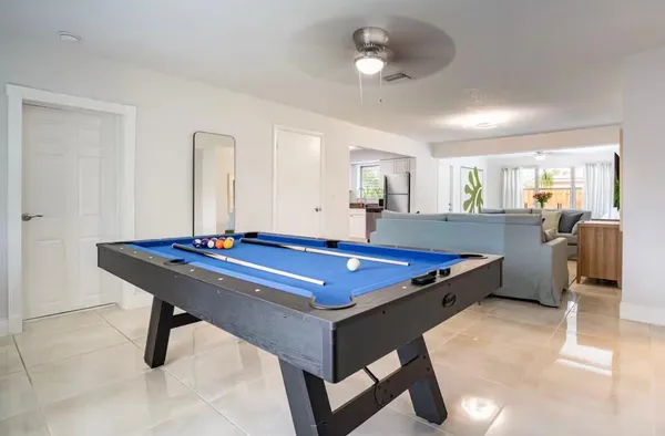 a room with pool table and windows