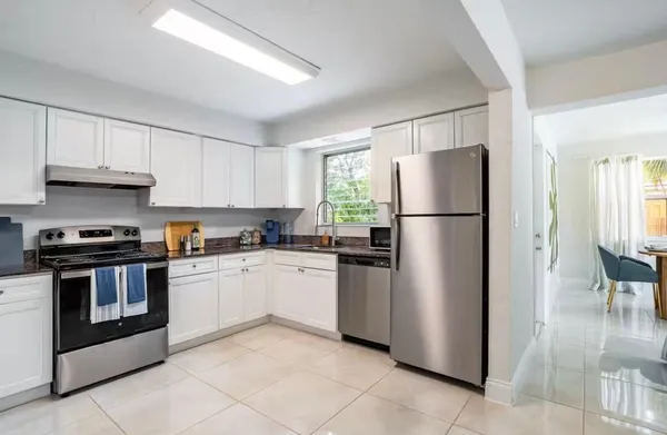 a kitchen with stainless steel appliances granite countertop a refrigerator stove a sink and a granite counter tops