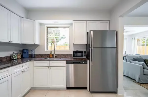 a kitchen with white cabinets and refrigerator