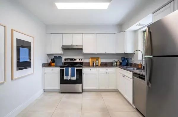 a kitchen with granite countertop a refrigerator and a stove top oven