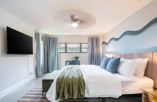 a bed sitting in a bedroom next to a window
