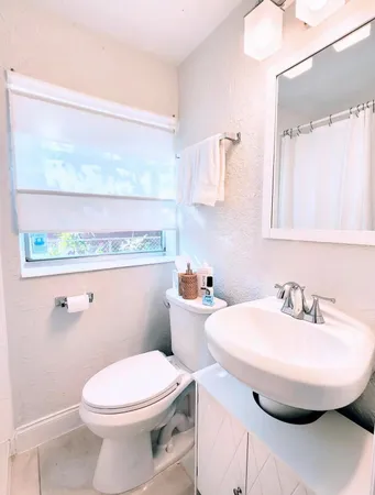 a bathroom with a sink a toilet and mirror