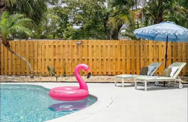 a view of a swimming pool with a lawn chairs under an umbrella