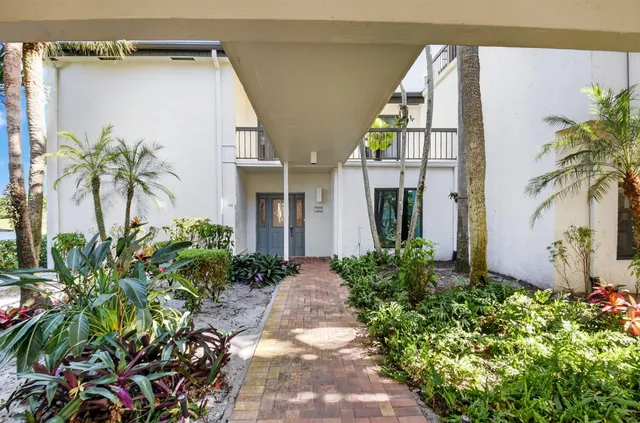 an aerial view of a house with a garden and lake view