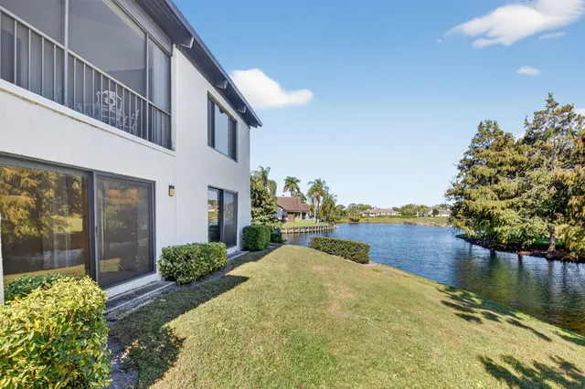 a front view of multi story residential apartment building with yard and green space