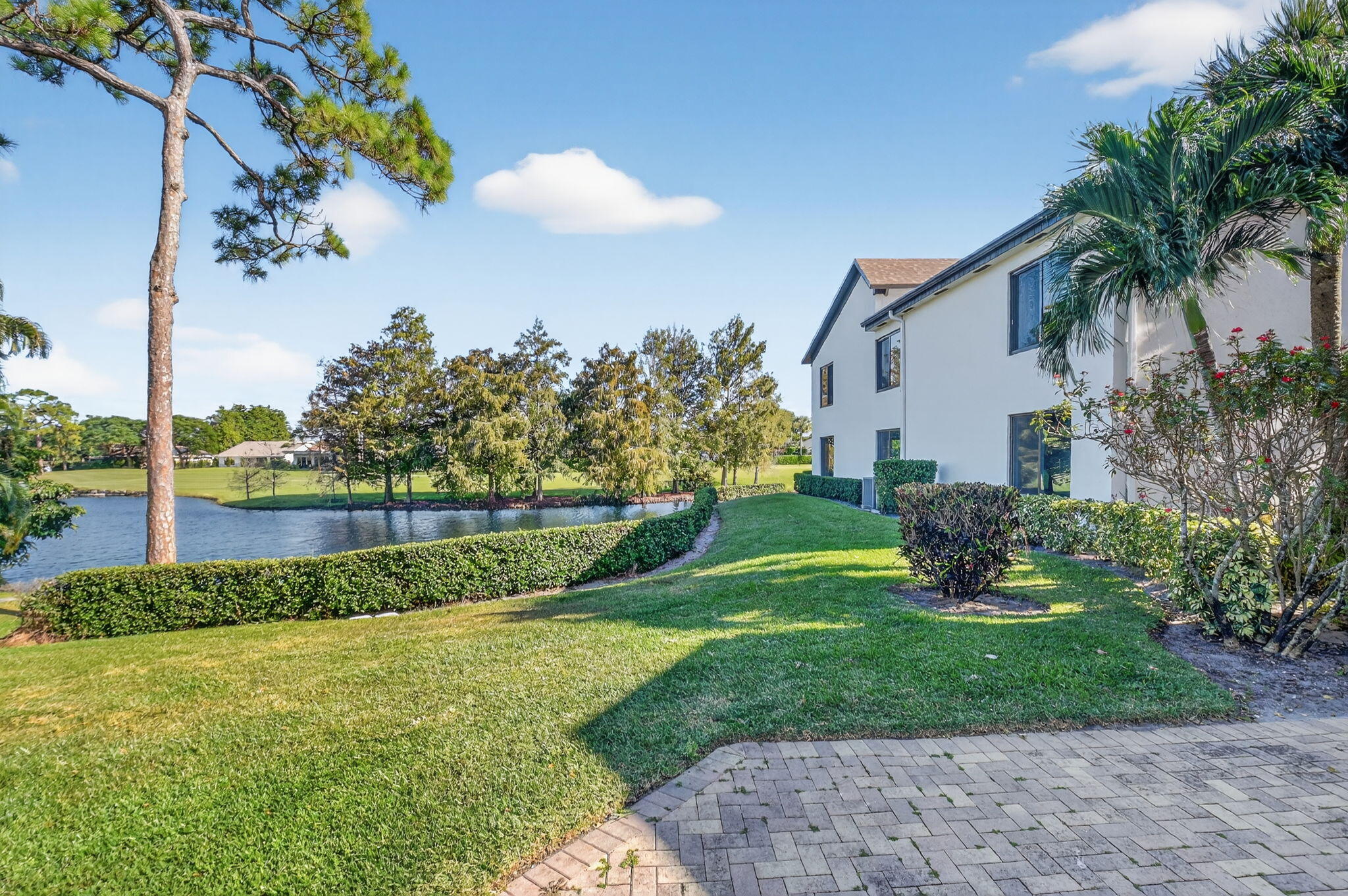 900 Greensward Lane, Unit 101G Delray Beach, FL 33445 - Photo 47 of 62 a view of a backyard with potted plants and palm trees