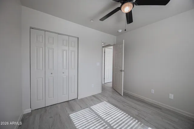 a view of a room with a ceiling fan and wooden floor
