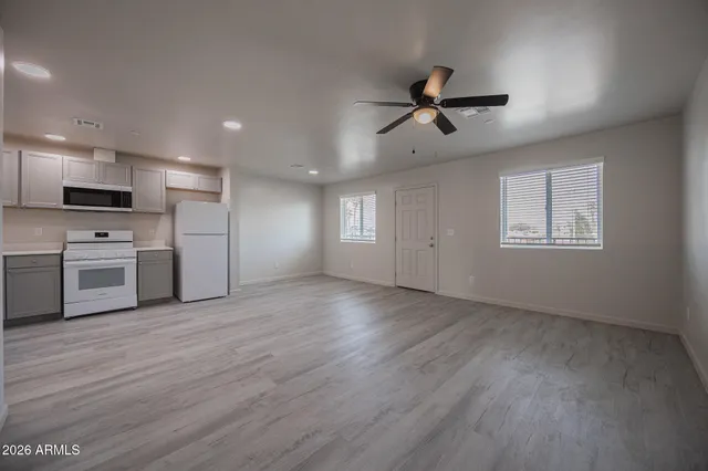 a view of a kitchen with a sink stove refrigerator and cabinets