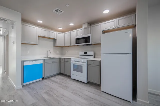 a kitchen with stainless steel appliances granite countertop a refrigerator a stove top oven a sink and cabinets