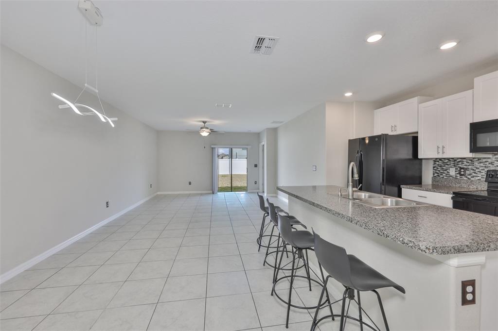 797 Olive Conch Street Ruskin, FL 33570 - Photo 5 of 53 a dining hall with stainless steel appliances granite countertop a stove a refrigerator a sink a dining table and chairs