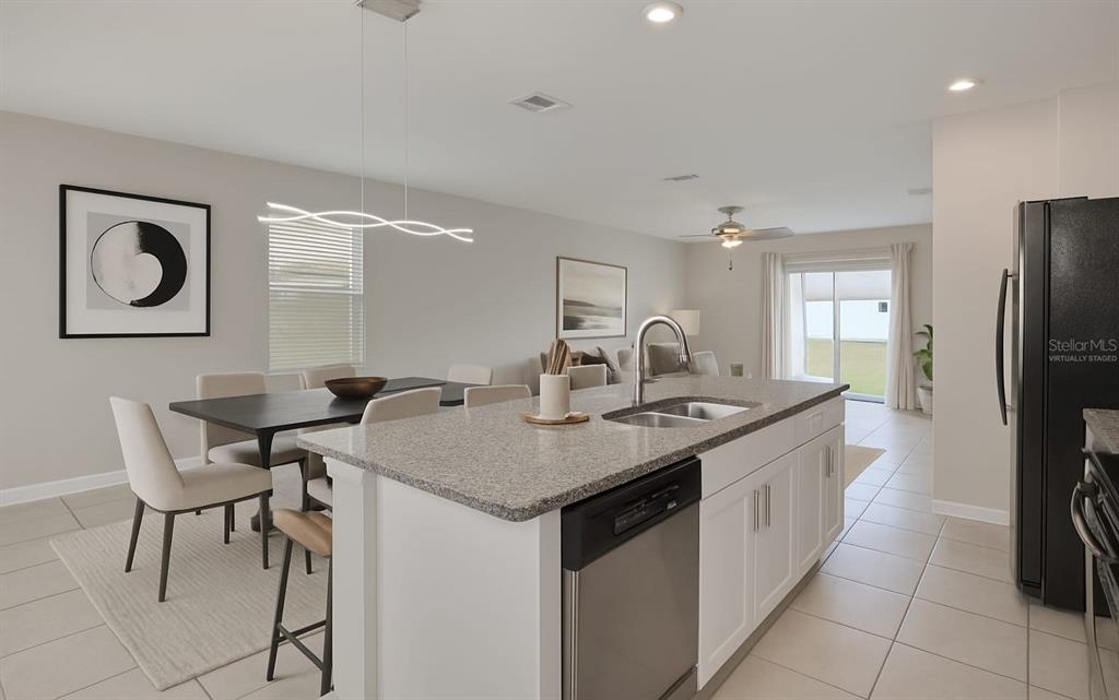 797 Olive Conch Street Ruskin, FL 33570 - Photo 6 of 53 a kitchen with a table chairs refrigerator and cabinets