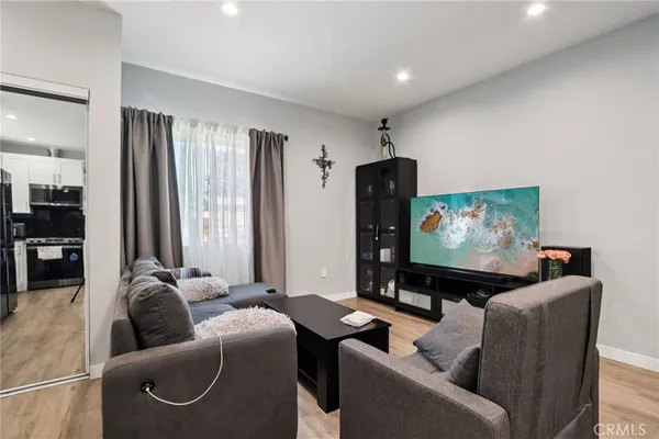 a living room with furniture and a wooden floor