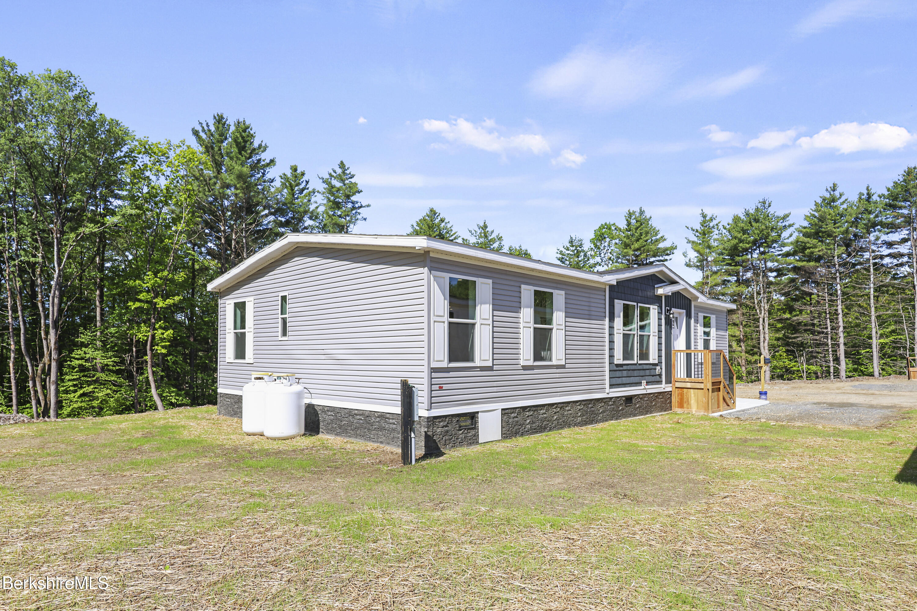 395 Cheshire Road, Unit 112 Pittsfield, MA 01201 - Photo 2 of 32 a front view of house with yard and trees in the background