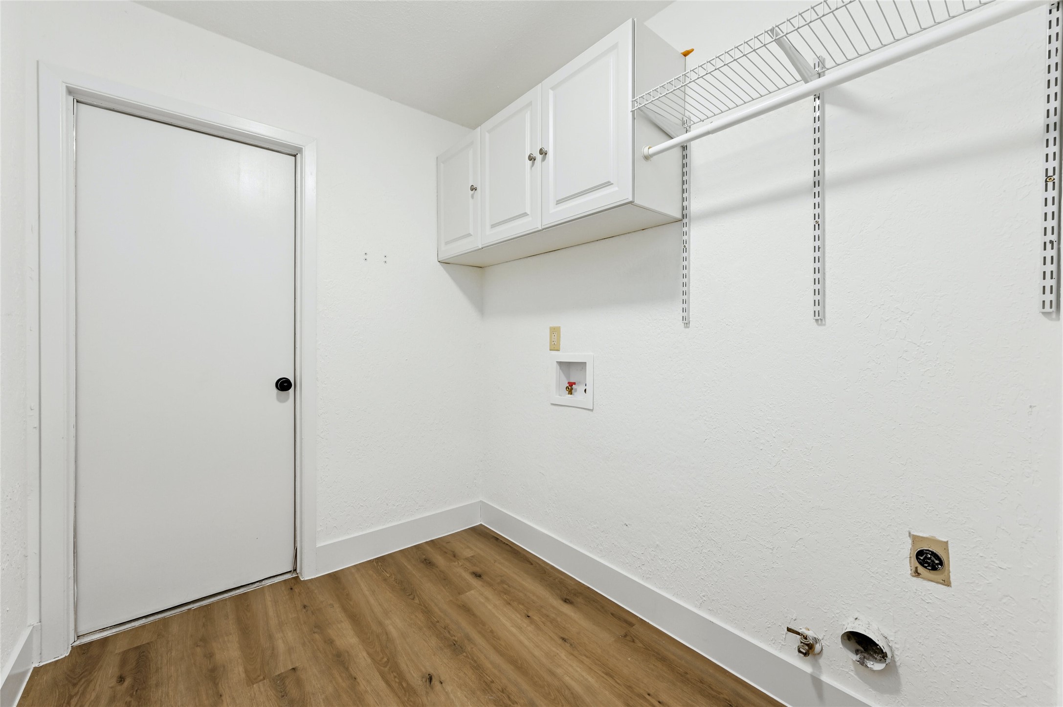 4808 Wind River Road Austin, TX 78759 - Photo 17 of 21 Functional laundry space features clean walls, vinyl plank flooring, and integrated overhead cabinets.