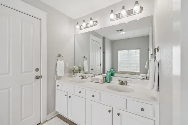 a bathroom with double vanity sink a mirror and vanity