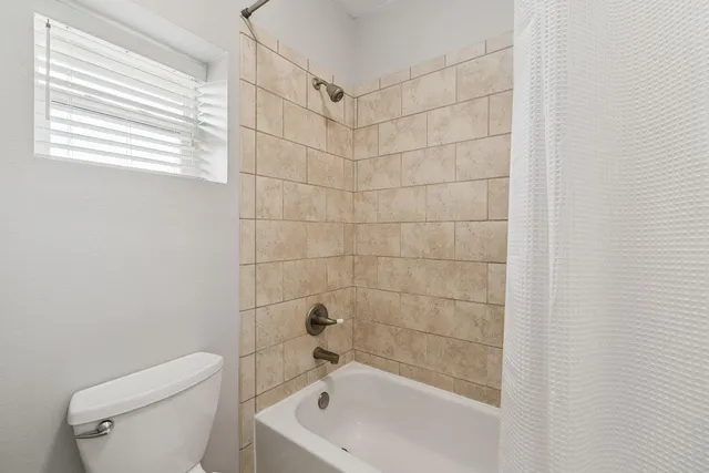 a bath room with a toilet a sink and bath tub