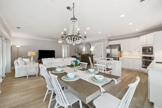 a view of a dining room with furniture a chandelier and wooden floor