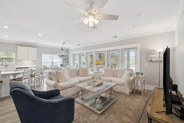 a living room with furniture a ceiling fan and a flat screen tv