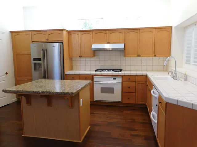 a kitchen with stainless steel appliances granite countertop a sink stove and refrigerator