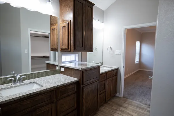 a bathroom with a granite countertop sink and a mirror