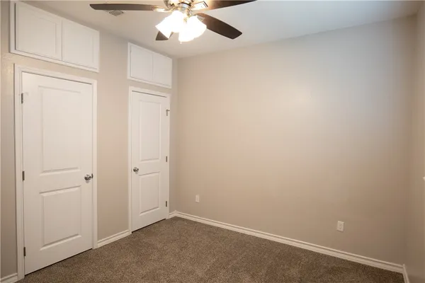an empty room with a chandelier fan