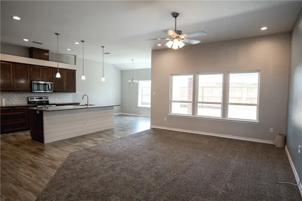 a large kitchen with kitchen island a large counter space a sink appliances and a window