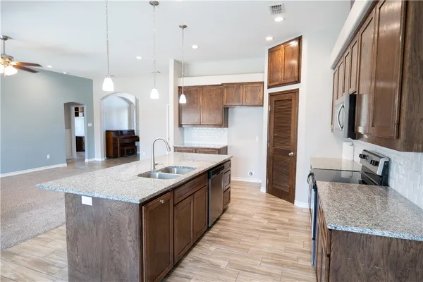 a kitchen with stainless steel appliances granite countertop a sink stove and refrigerator