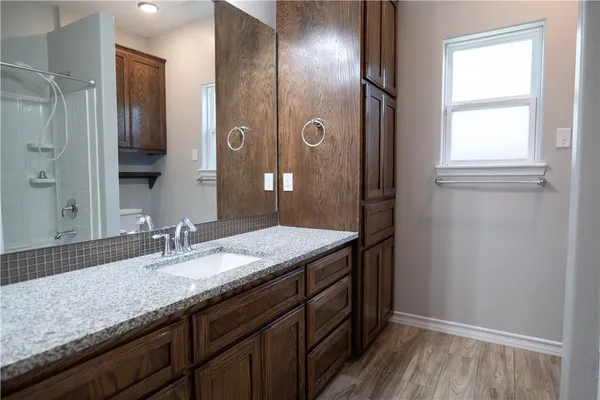 a bathroom with a granite countertop sink and a mirror