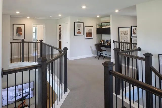 a view of a hallway with wooden floor and windows