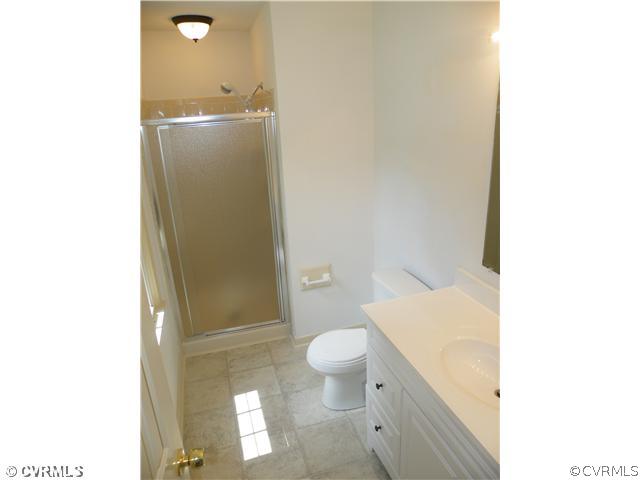 4703 Wilconna Road Chesterfield, VA 23832 - Photo 9 of 12 a bathroom with a granite countertop sink toilet and shower