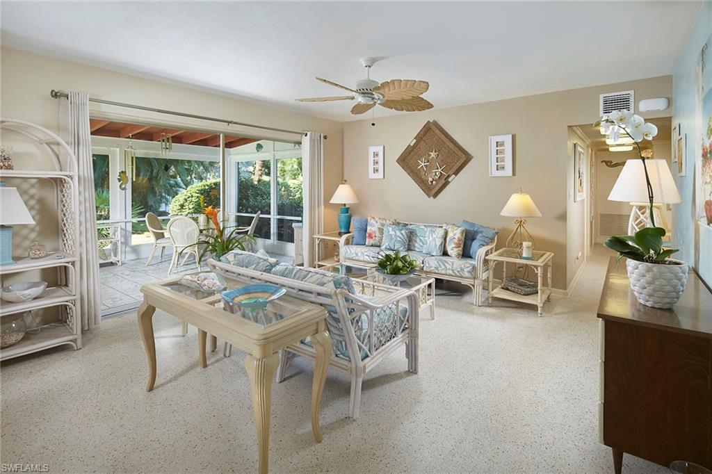 1829 Mandarin Road Naples, FL 34102 - Photo 2 of 14 a living room with furniture a chandelier and a window