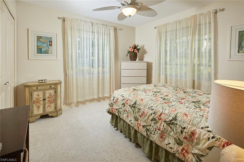 1829 Mandarin Road Naples, FL 34102 - Photo 7 of 14 a bedroom with a bed and a chandelier