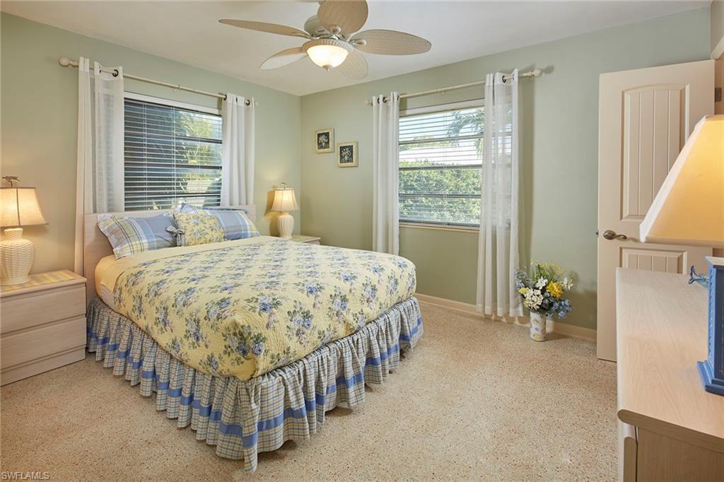 1829 Mandarin Road Naples, FL 34102 - Photo 9 of 14 a bedroom with a bed and a chandelier