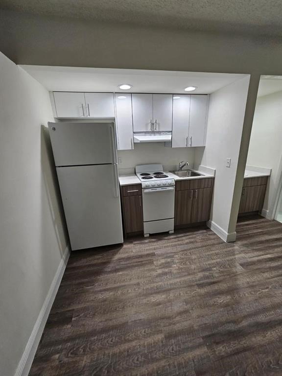 a kitchen with a refrigerator and a stove top oven