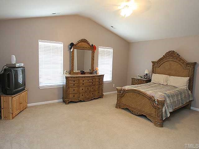 4102 Springfield Creek Drive Raleigh, NC 27616 - Photo 6 of 10 a bedroom with a bed closet and flat tv screen