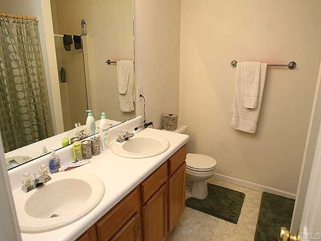 4102 Springfield Creek Drive Raleigh, NC 27616 - Photo 7 of 10 a bathroom with a sink a toilet and a mirror