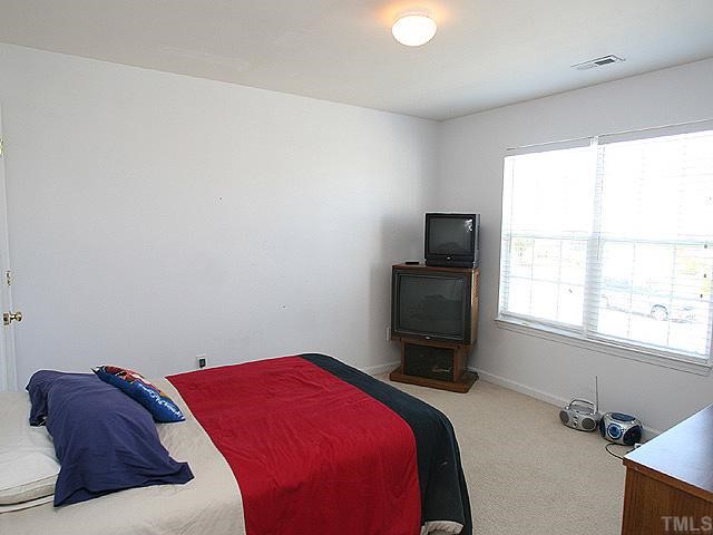 4102 Springfield Creek Drive Raleigh, NC 27616 - Photo 8 of 10 a bedroom with a bed and a flat screen tv